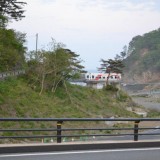 水門の上に三陸鉄道​の車両と仮設住宅