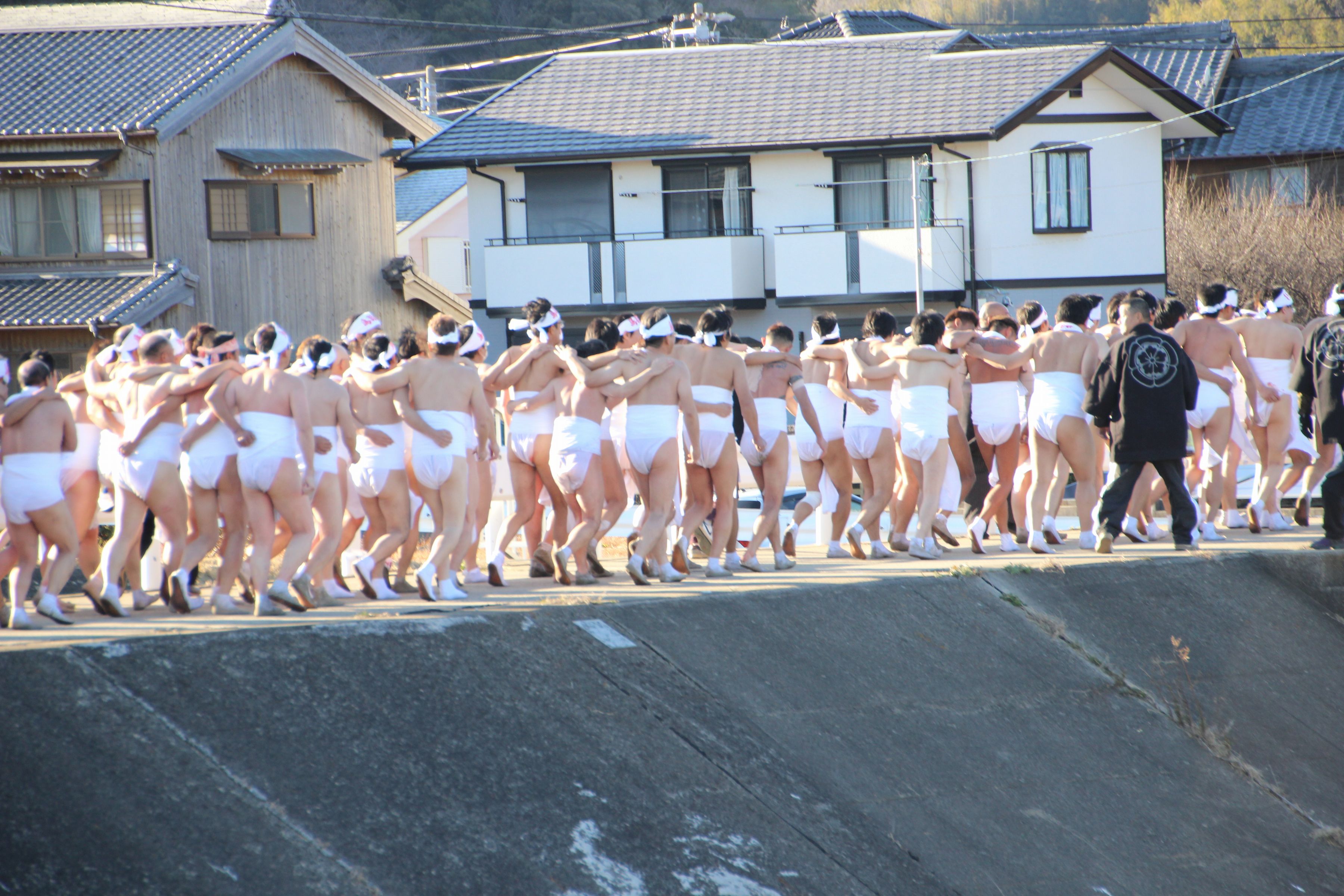 みそぎを済ませ、肩を組んで戻る神男と奉仕者たち