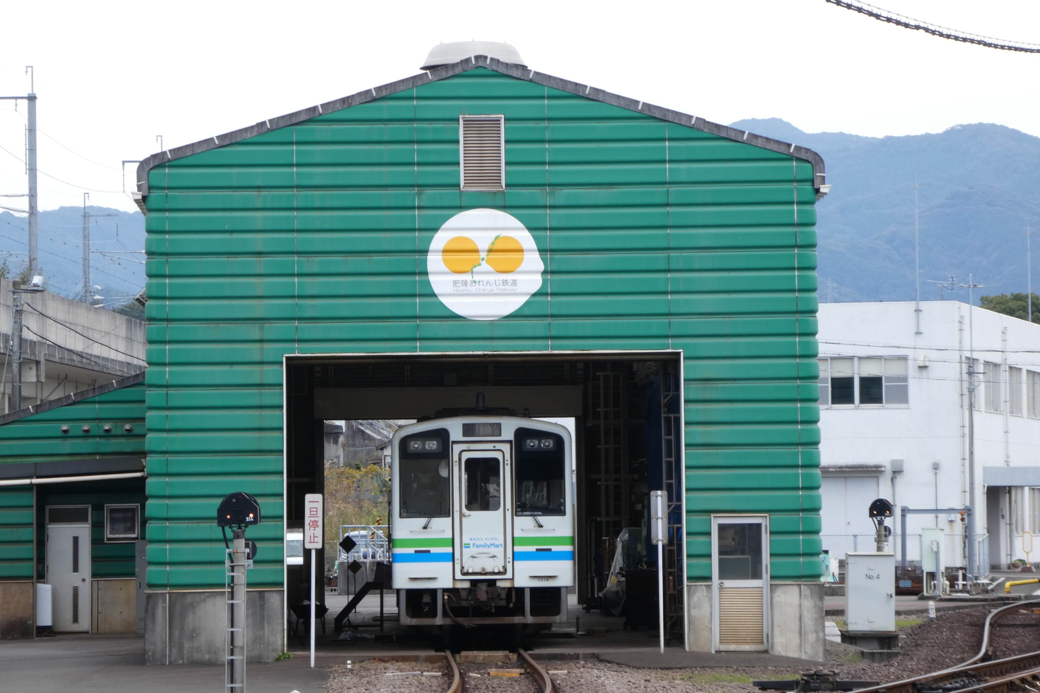 車両基地の建屋に『ファミリーマートラッピング車両』が鎮座