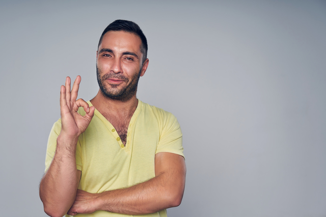 Closeup of casual hispanic man gesturing OK