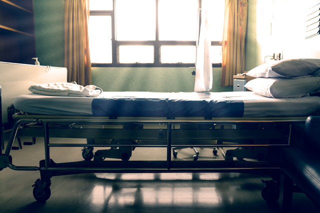 Empty hospital bed with sunlight from the window,vintage tone