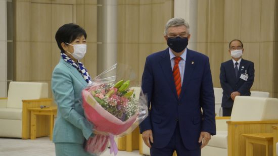 東京都庁を表敬訪問したバッハ会長（右）から花束を受け取る小池百合子・東京都知事（左）