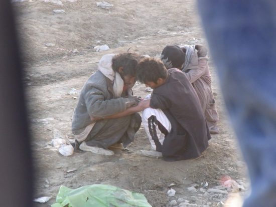 カブール市内の河原で液体化したヘロインを腕に打つアフガニスタン人の若者