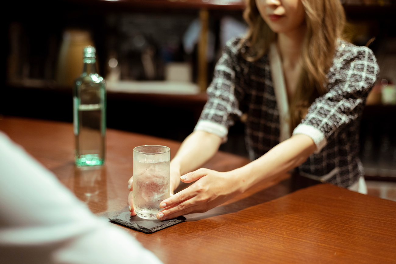 カウンターバーでお酒を提供する女性