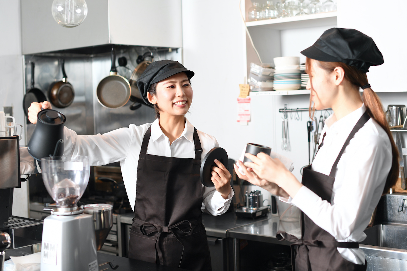 飲食店で働くエプロン姿の女性達