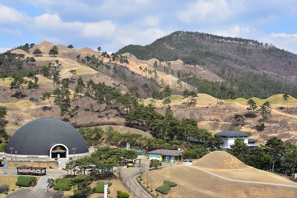 池山洞古墳群と主山城（右下の白い建物が博物館、ドームは王陵展示館）