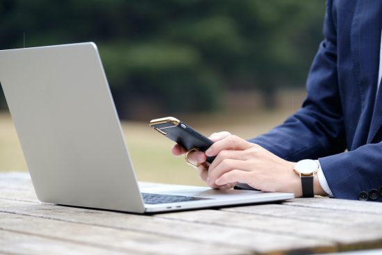 屋外でスマホを操作する男性ビジネスマン