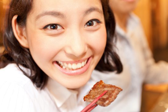 焼肉を食べる女性