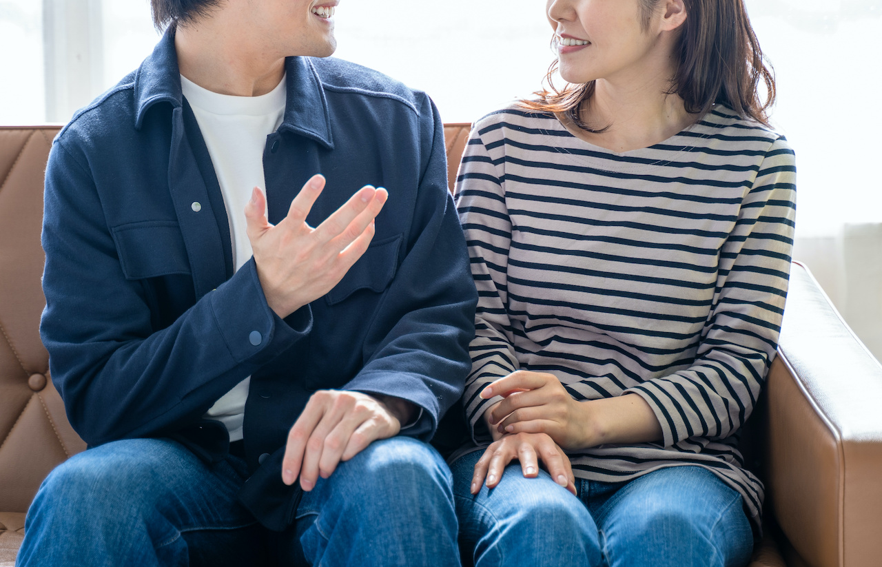 ソファに座り会話する夫婦