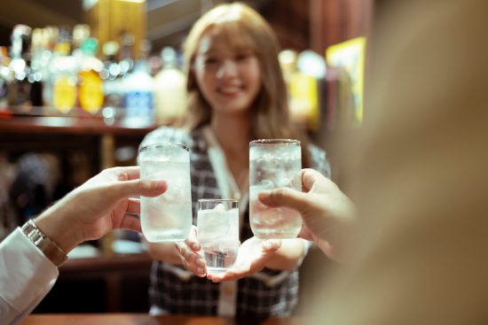 カウンターバーでお酒を提供する若い女性