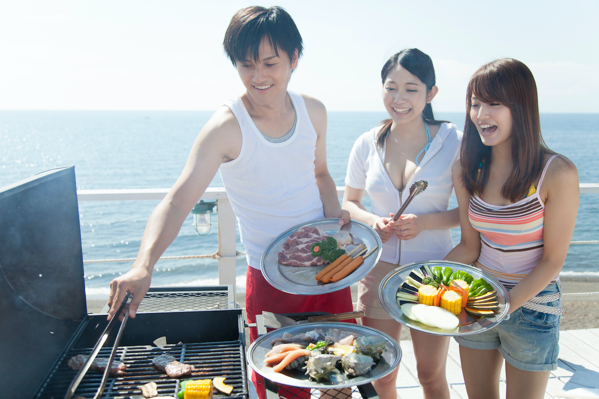 海辺でBBQをする男女