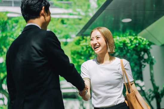 屋外で握手する男女