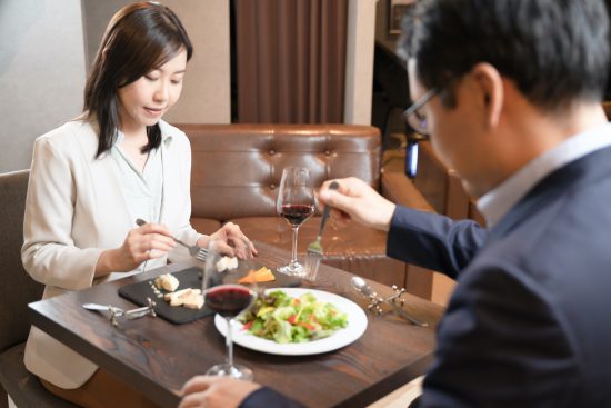 レストランで会話をしながら食事をする男女