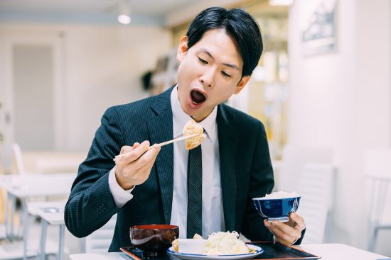 定食を食べる日本人男性