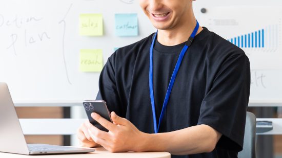 スマホを使う笑顔の男性ビジネスマン